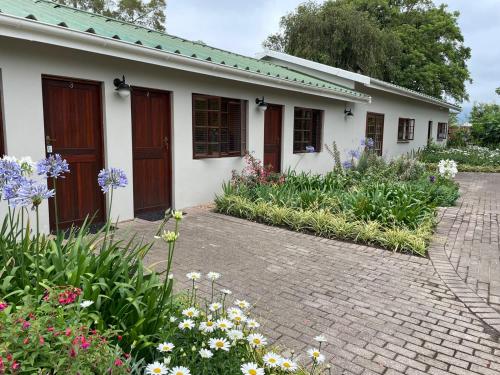 a house with flowers in front of it at Farmlands Guesthouse in George