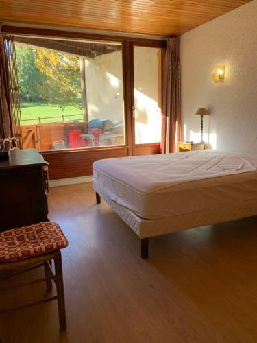 une chambre avec un lit et une grande fenêtre dans l'établissement Appartement au pied des pistes, à Uvernet