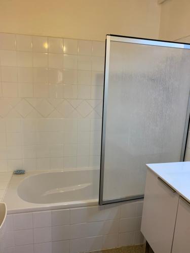 La salle de bains est pourvue d'une baignoire et d'une cabine de douche. dans l'établissement Appartement au pied des pistes, à Uvernet