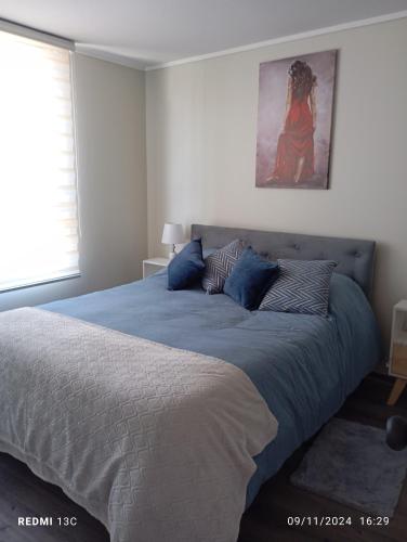 a bedroom with a large bed with blue sheets at Disfruta de Valparaiso in Valparaíso