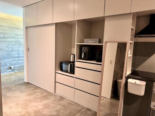 a kitchen with white cabinets and a microwave at Mountain View Villa - Heated Big Pool-Quinta da BellaVista in Santarém