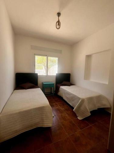 a room with two beds and a window at El Olivar - Casa Rural - Ain Zarka - عين الزرقاء in Tetouan