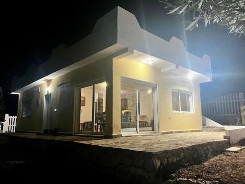a house with a large glass door in the night at El Olivar - Casa Rural - Ain Zarka - عين الزرقاء in Tetouan