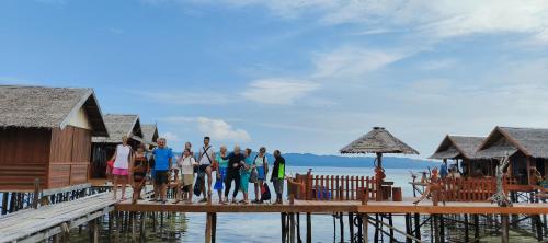 a group of people standing on a dock at Happy Homestay Arborek in Besir