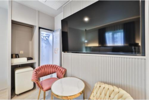 a room with a table and two chairs and a kitchen at Deokcheon Den Basta Hotel in Busan