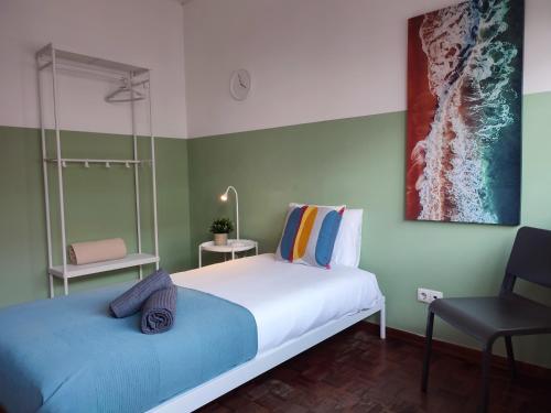 a bedroom with a large bed and a chair at Casa da Baixa in Faro