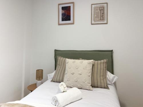 Un dormitorio con una cama con sábanas y almohadas blancas. en TAYP San Marcos 104, en Talayuela