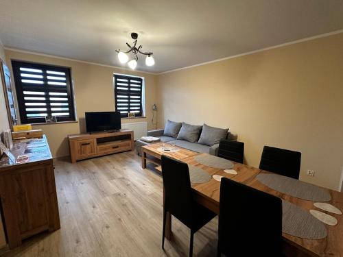 a living room with a table and a couch at Apartamenty ALICJA in Dzierżoniów