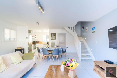 un salon avec un canapé blanc et une table dans l'établissement Biscarrosse Plage Maison à 600m des plages pour 6 personnes, à Biscarrosse-Plage