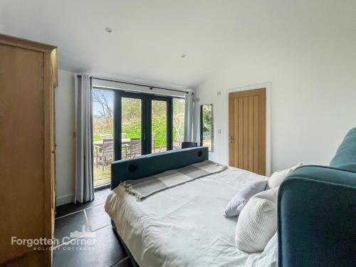 a bedroom with a large bed and a sliding glass door at Wiggle Barn in Torpoint