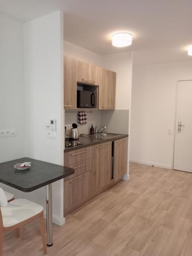 a kitchen with wooden cabinets and a table at DOMITYS - Le Fil de Soie in Calais