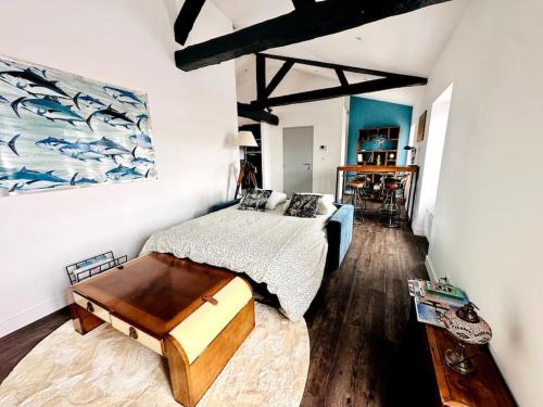 une chambre avec un lit et un tableau au mur dans l'établissement Le Gambetta - Marché Central, à La Rochelle