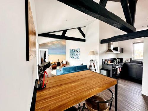 Il comprend une cuisine et un salon avec une table en bois. dans l'établissement Le Gambetta - Marché Central, à La Rochelle