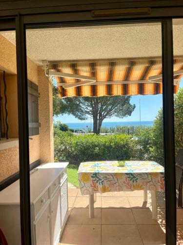 une cuisine avec une table et une vue sur l'océan dans l'établissement Les Issambres, appt accès direct plage sable, idéal 4 pers, vue mer, Clim, à Roquebrune-sur Argens