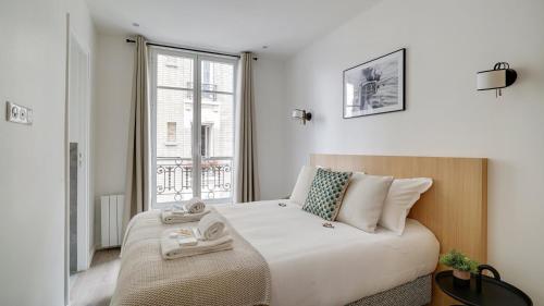 une chambre avec un lit et une fenêtre dans l'établissement 153 Suite Mylene - Superbe Appartement à Paris, à Paris