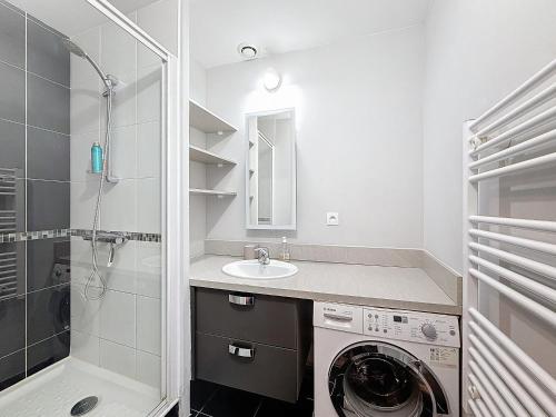 une salle de bain avec une machine à laver et un lavabo dans l'établissement La Baie, Terrasse, Parking privé, à 5min à pieds de la digue de Wimereux, à Wimereux