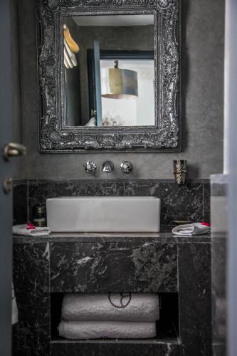 a bathroom with a sink and a mirror and towels at Riad Origines in Marrakech