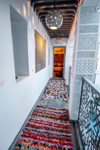 a hallway with a colorful rug on the floor at Riad Origines in Marrakech