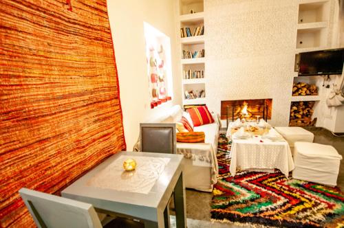 a living room with a table and a fireplace at Riad Origines in Marrakech