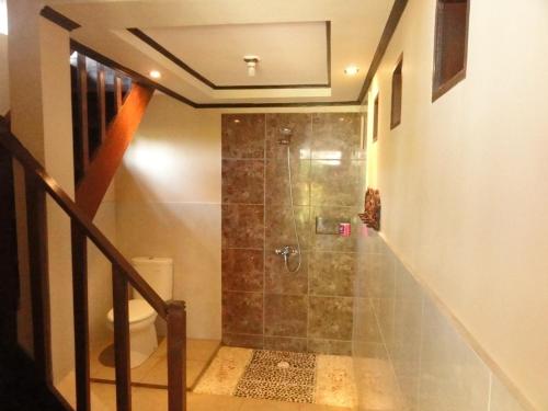baño con ducha a ras de suelo junto a un aseo en Villas Ganjor, en Gili Meno