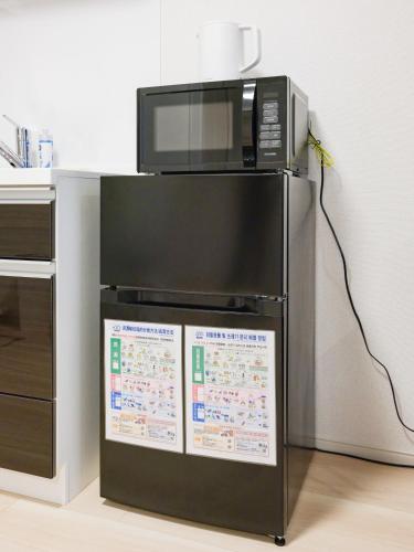 a microwave sitting on top of a refrigerator at Shinjuku Tokyo Holiday Hotel in Tokyo