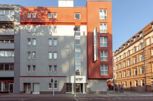 a building on a city street with buildings at Garner Hotel Mannheim City by IHG in Mannheim