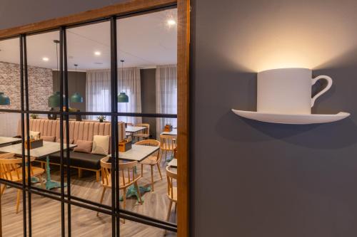a cup on a shelf on the wall of a restaurant at Garner Hotel Mannheim City by IHG in Mannheim