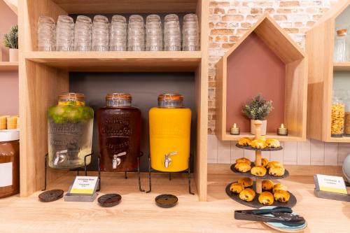 a shelf with two large bottles of juice and some food at Garner Hotel Mannheim City by IHG in Mannheim