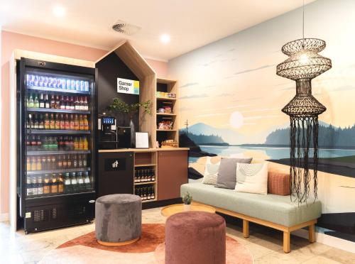 a wine tasting room with a couch and a wine refrigerator at Garner Hotel Mannheim City by IHG in Mannheim