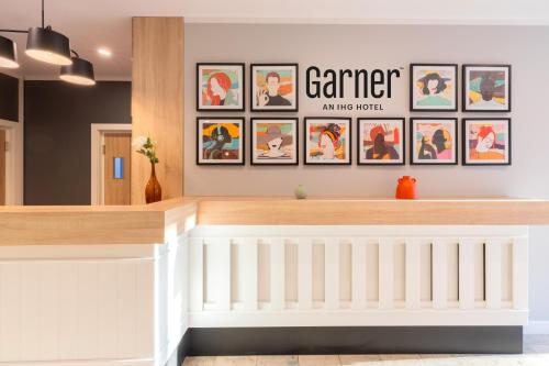 a white crib in a room with pictures on the wall at Garner Hotel Mannheim City by IHG in Mannheim