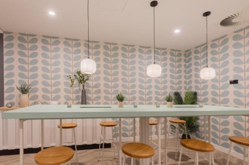 a dining room with a table and stools at Garner Hotel Mannheim City by IHG in Mannheim
