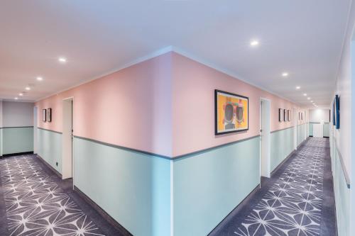 a hallway in a building with a painting on the wall at Garner Hotel Mannheim City by IHG in Mannheim
