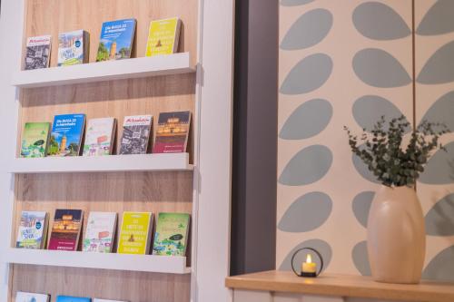a book shelf filled with books and a vase of flowers at Garner Hotel Mannheim City by IHG in Mannheim