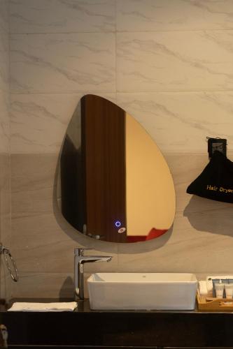 a bathroom with a sink and a mirror on the wall at The Stallion Abuja in Abuja