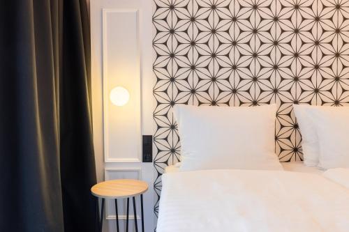 a bedroom with a white bed and a wall at Garner Hotel Mannheim City by IHG in Mannheim