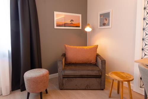a living room with a chair and a lamp at Garner Hotel Mannheim City by IHG in Mannheim