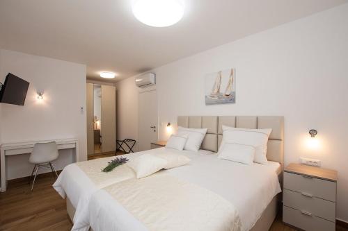 a bedroom with a large white bed with white pillows at Villa Stella - CROWONDER LUXURY RENT in Turanj