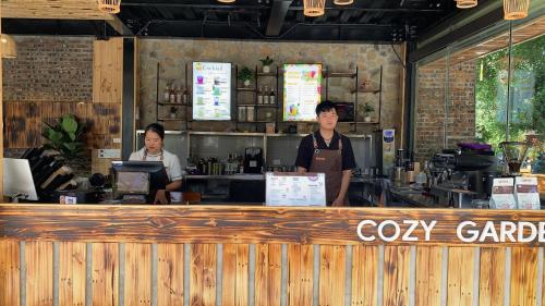 two people standing at the counter of a coffee shop at Tam Coc Lavender Homestay -Authentic Ninh Binh Experiences in Ninh Binh
