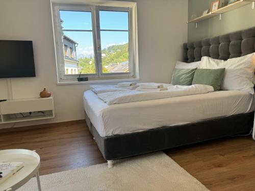 a bedroom with a large bed with a large window at Ferienwohnung Millstatt in Millstatt