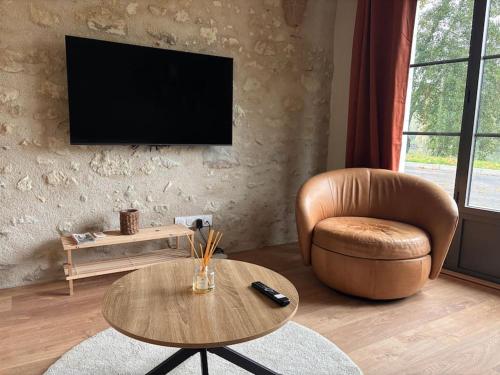 a living room with a chair and a table at Châteaux de la Loire - Près de Tours - Cottage EAU CALME en Bord de Lac in Saint-Avertin