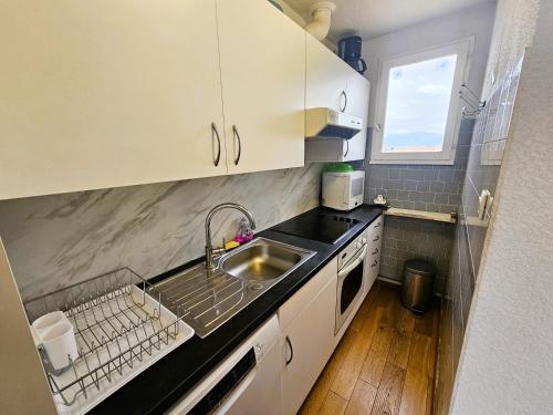 une petite cuisine avec un évier et une fenêtre dans l'établissement 2 Chambres avec Grande terrasse de 25m² à 350M de la Plage, à Saint-Mandrier-sur-Mer