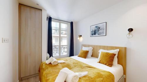 - une chambre avec un lit doté de draps jaunes et une fenêtre dans l'établissement 158 Suite Jeremy - Superbe Appartement à Paris, à Paris