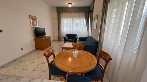a living room with a table and chairs and a television at Uptown Hotel Apartments Abu Dhabi by Gewan in Abu Dhabi