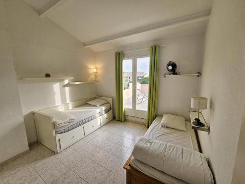 une petite chambre avec deux lits et une fenêtre dans l'établissement 2 Chambres avec Grande terrasse de 25m² à 350M de la Plage, à Saint-Mandrier-sur-Mer