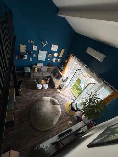 Elle comprend un salon avec des murs bleus et un grand sol. dans l'établissement Magnifique Duplex à proximité Aix en Provence, à Éguilles