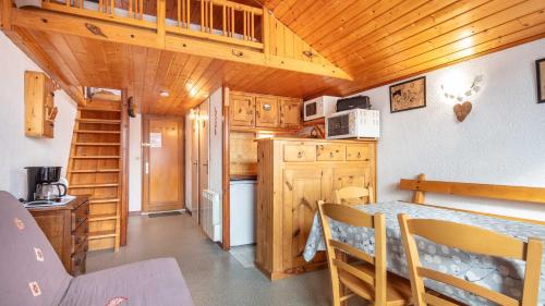 - une cuisine avec des placards en bois et une table dans une cabine dans l'établissement VISONS - 11 - Studio Mezzanine 6 pers, à Saint-Sorlin-dʼArves
