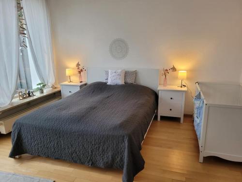 a bedroom with a bed with two night stands and two windows at Ferienwohnung Landidyll, Whirlpool, Minipigs, Ponys, Familien in Halver
