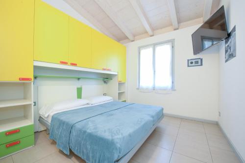 a bedroom with a bed and yellow cabinets at Campeggio Europa Silvella in San Felice del Benaco