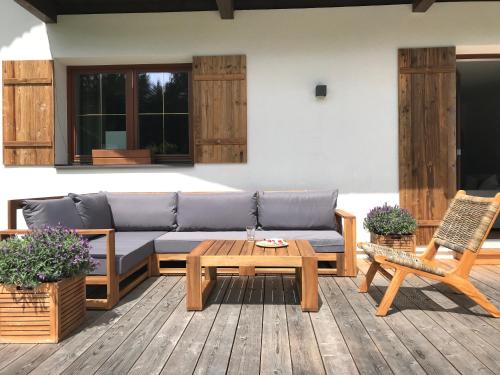 a patio with a couch and a table and a chair at Schneehaus Lodge in Ehrwald