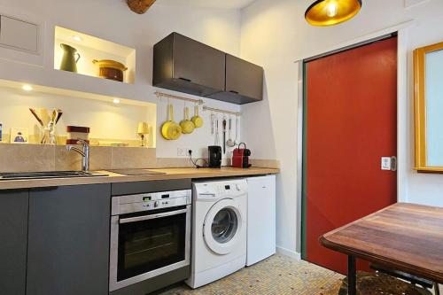 une cuisine avec une machine à laver et un évier dans l'établissement Studio chaleureux et atypique au coeur de Sète, à Sète